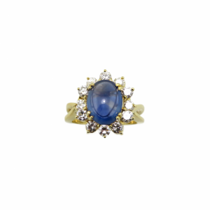 Cabochon cut Oval Blue Sapphire surrounded by 12 top quality diamonds in 18kt ring